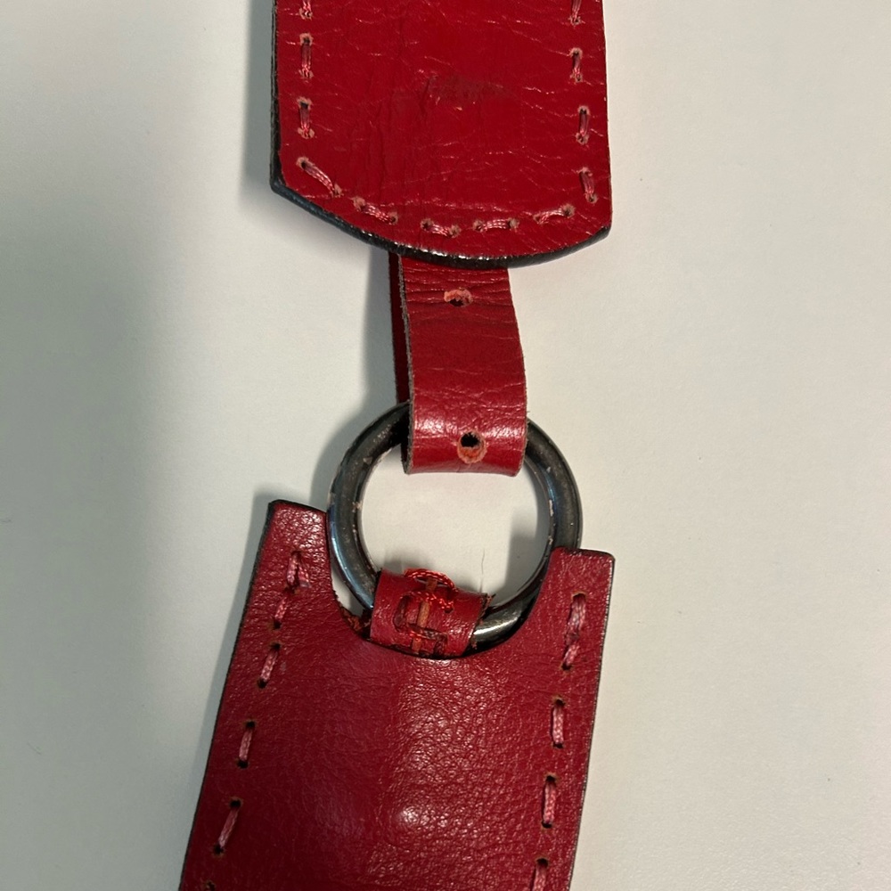 Red leather belt, adjustable length. Metal rings, (tarnished)